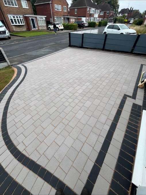 Light grey block paved driveway with curved charcoal border edging